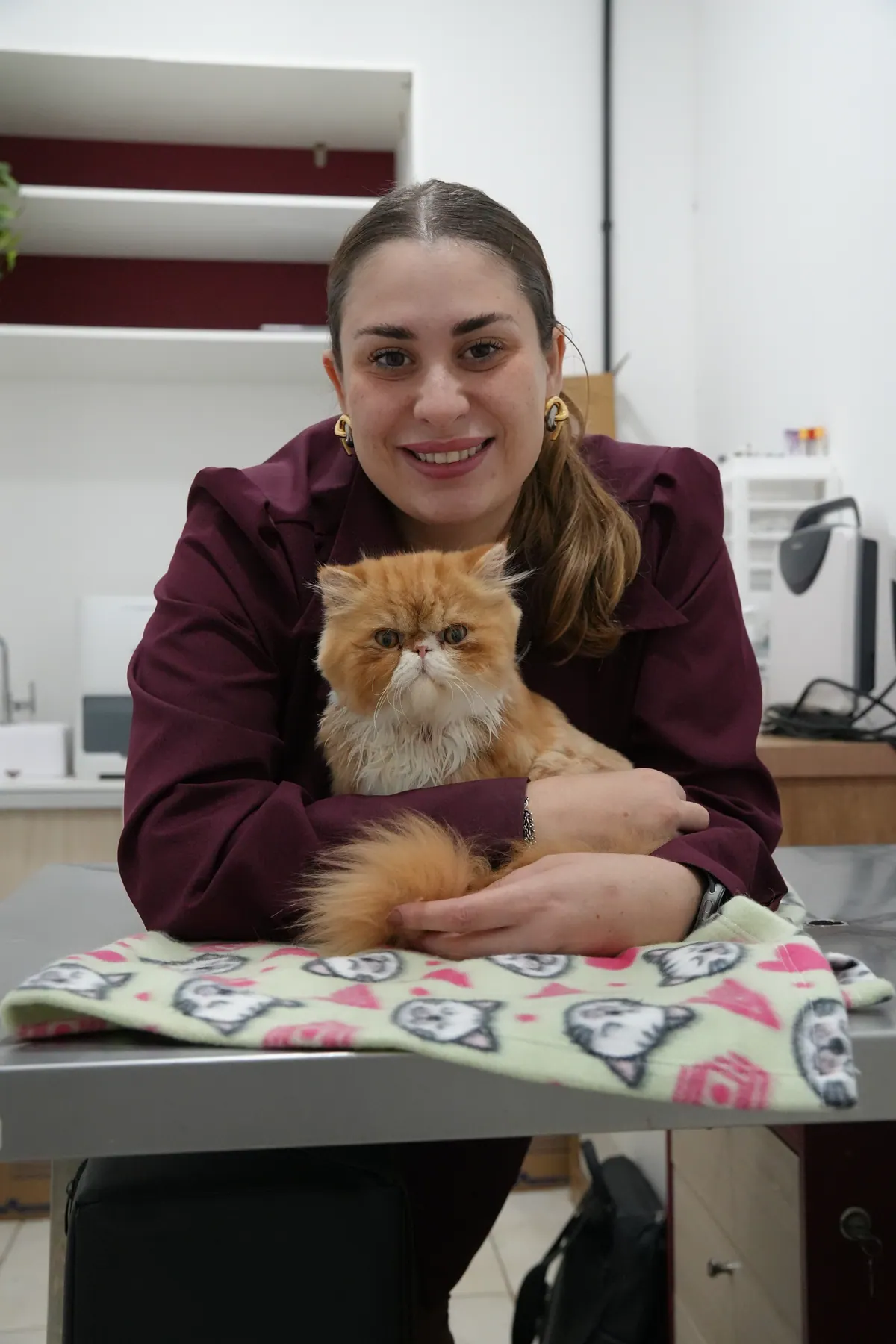Dra. Polyana Pivovar, veterinária da Emporium Pet, com um gato no colo dentro da clínica